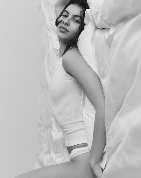 Person lying on a bed in a black and white photo